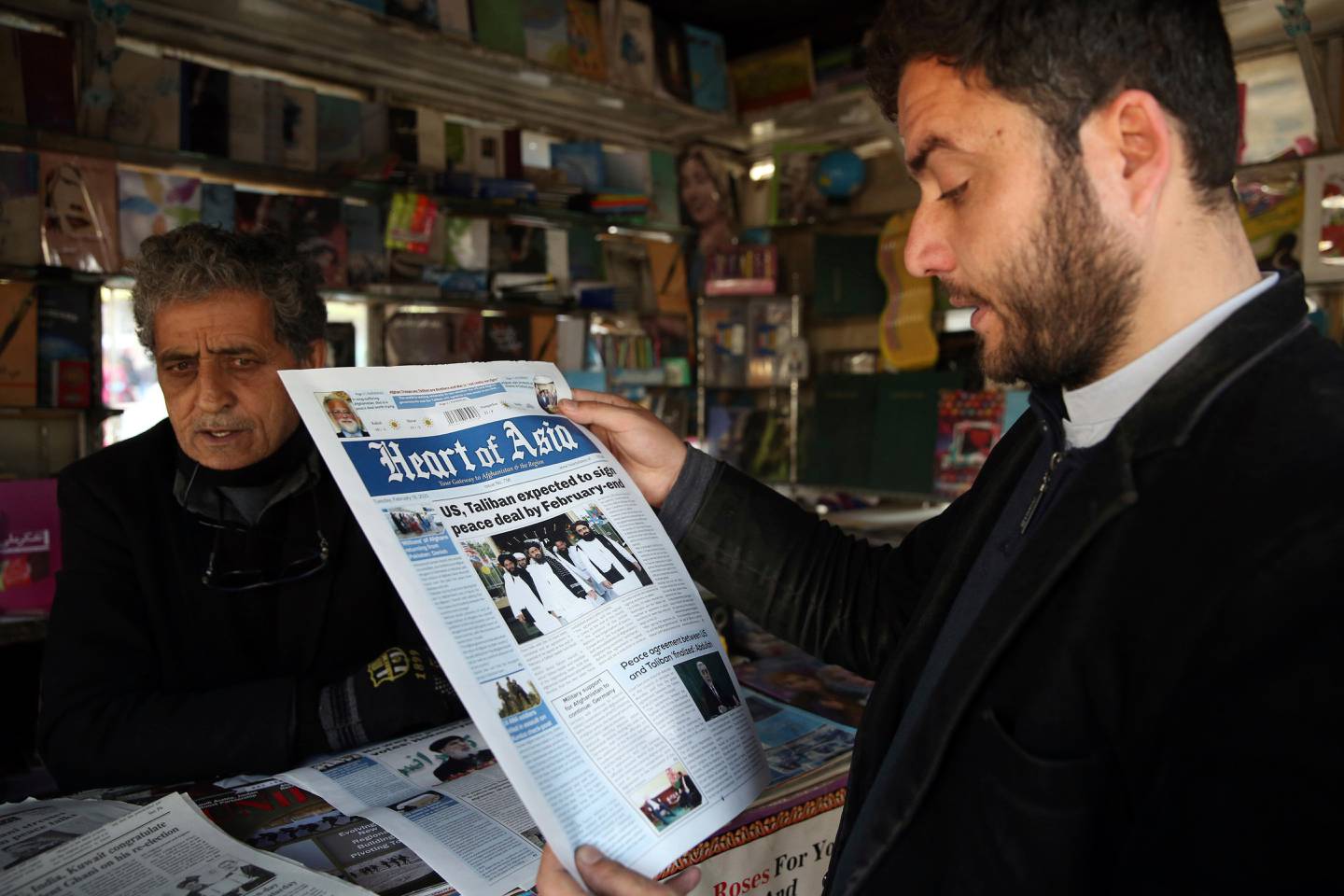 A man reads a newspaper about peace talks in Kabul, Afghanistan. Saturday, Feb. 22, 2020. A temporary truce between the United States and the Taliban took effect on Friday, setting the stage for the two sides to sign a peace deal next week aimed at ending 18 years of war in Afghanistan and bringing U.S. troops home. (AP Photo/Rahmat Gul)