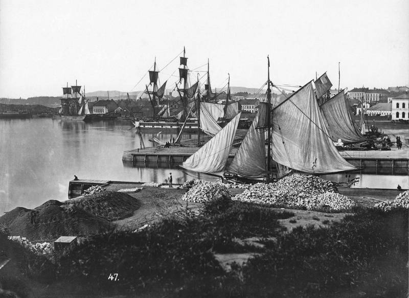 Aktiviteten på havna preget lenge lyden av Oslo med skipsfart, lossing og skipsbygging. Piperviksbryggene mot Akers mekaniske verksted og Vestbanestasjonen ca. 1880.