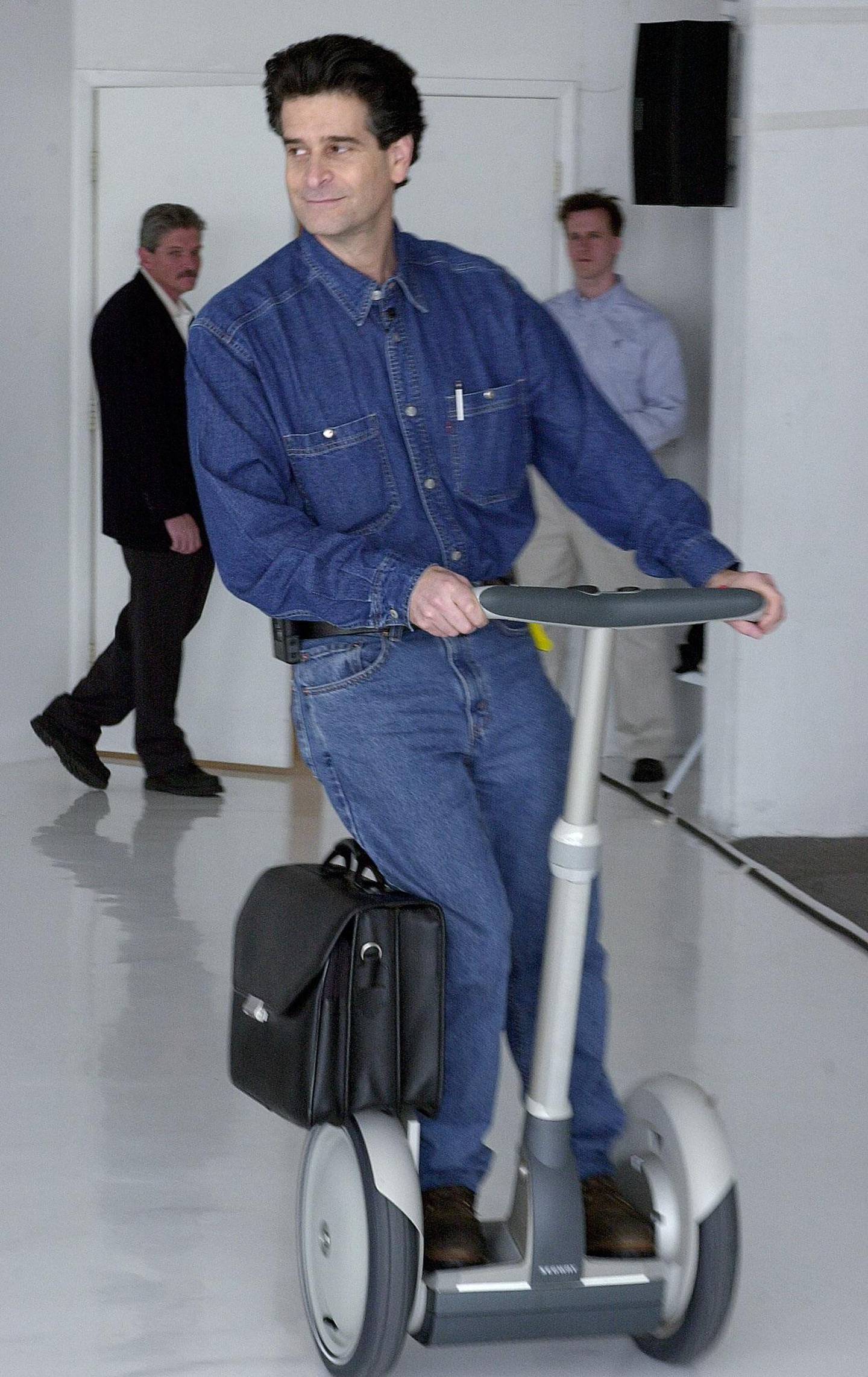 **FILE**  Inventor Dean Kamen leans to initiate a turn as he demonstrates his Segway Human Transporter, a one-person, battery-powered scooter, unveiled in this Monday, Dec. 3, 2001 file photo, in New York. Segway Inc. is recalling all 23,500 of the self-balancing scooters it has shipped to date because of a software glitch that can make its wheels unexpectedly reverse direction, causing riders to fall off.  (AP Photo/Suzanne Plunkett, FILE)