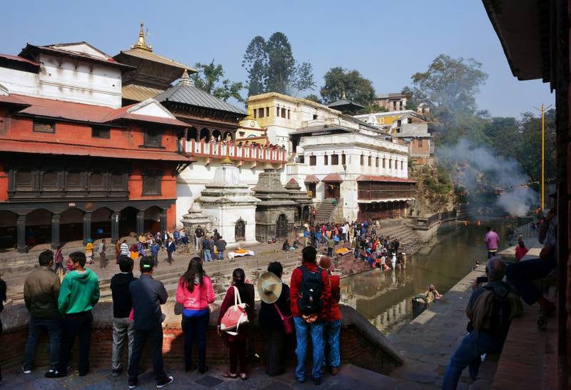 Turister og lokale følger med på renselses- og kremasjonsseremoniene langs Bagmati-elven utenfor hindutempelet Pashupatinath. FOTO: CHRISTINE BAGLO