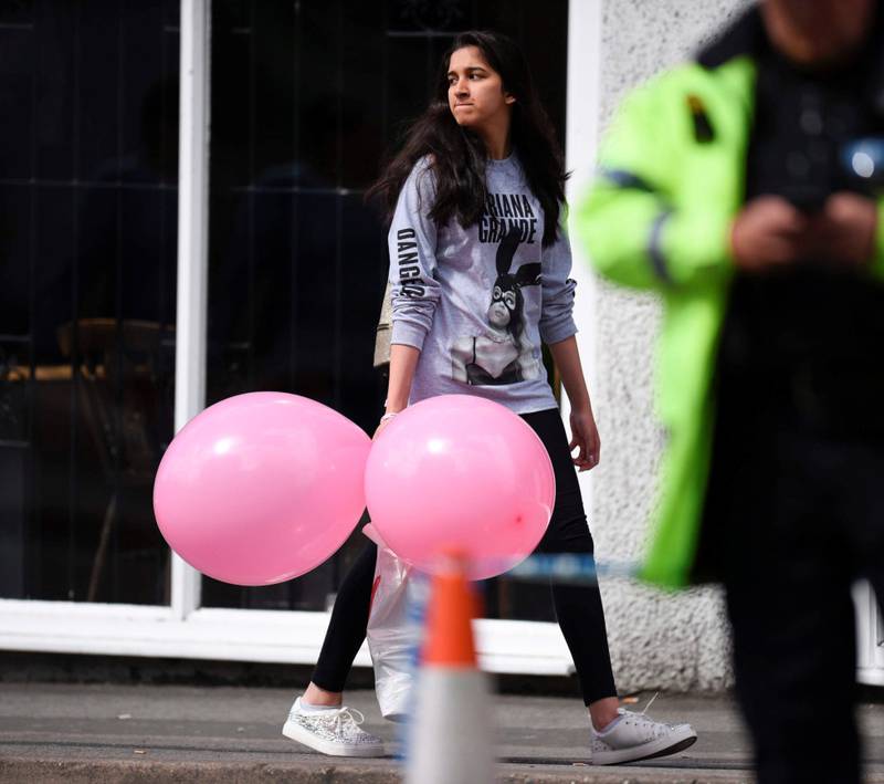 En tilhenger av Ariana Grande med ballonger og T-skjorte fra konserten, etter terrorangrepet mandag.  FOTO: OLI SCARFF/AP/NTB SCANPIX