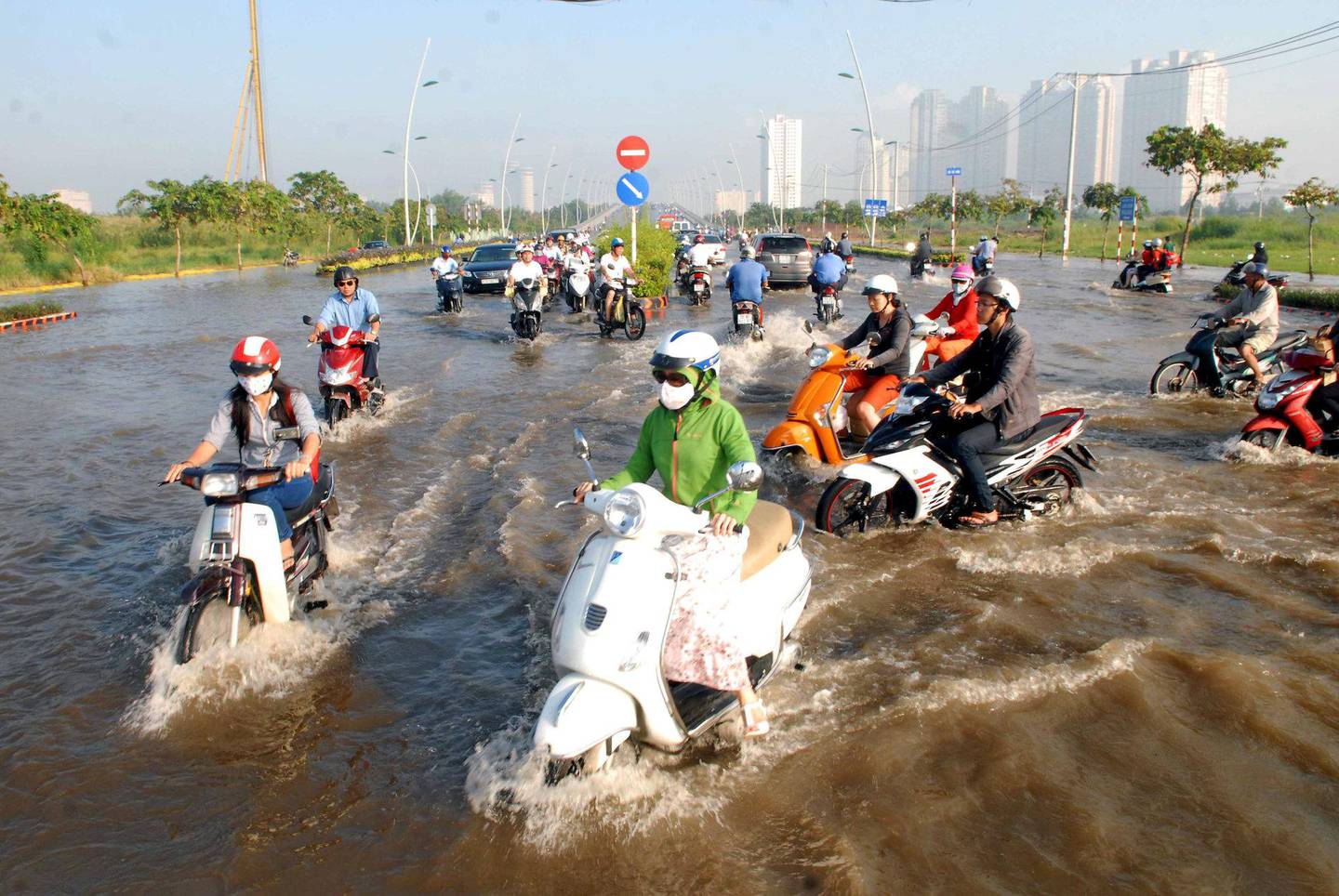 HO CHI MINH: Motorsyklister baner seg vei i vannet i Ho Chi Minh, tidligere Saigon, i Vietnam. FOTO: NTB SCANPIX