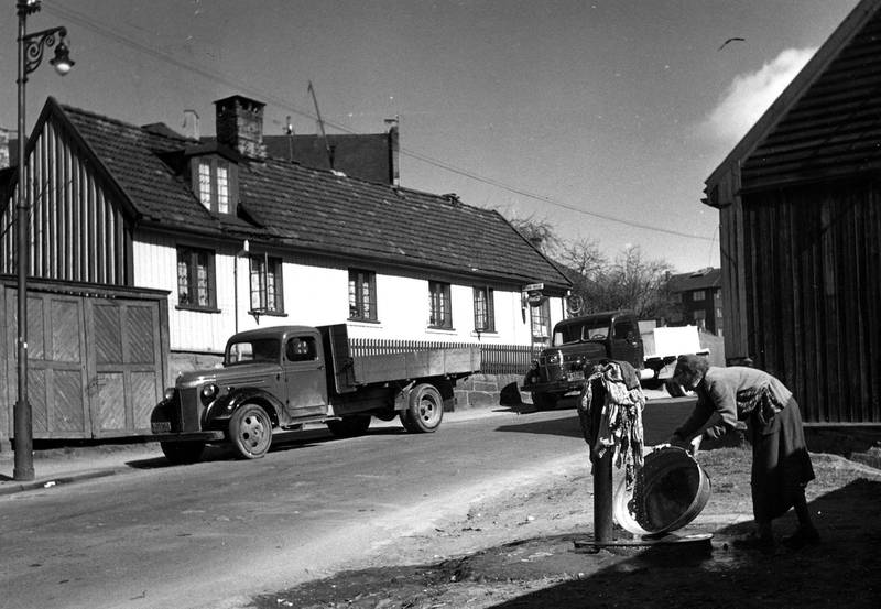 En kvinne skyller klesvaska i en vannpost i Maridalsveien 124 på Sagene. På slutten av 1950-tallet var fortsatt hver fjerde bolig i Oslo uten innlagt vann.