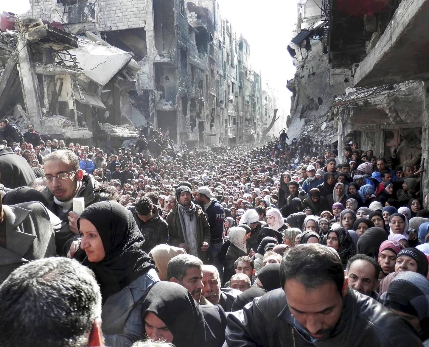 Bildet av palestinerne fra Yarmouk i matkø har nærmest blitt et bilde på hele krigen, brukt på bokomslag og utallige medieomslag om krisen. Ironisk nok peker flere nyhetskommentatorer på at palestinernes situasjon i Syria har vært blant de mest underkommuniserte. FOTO: Scanpix/AP