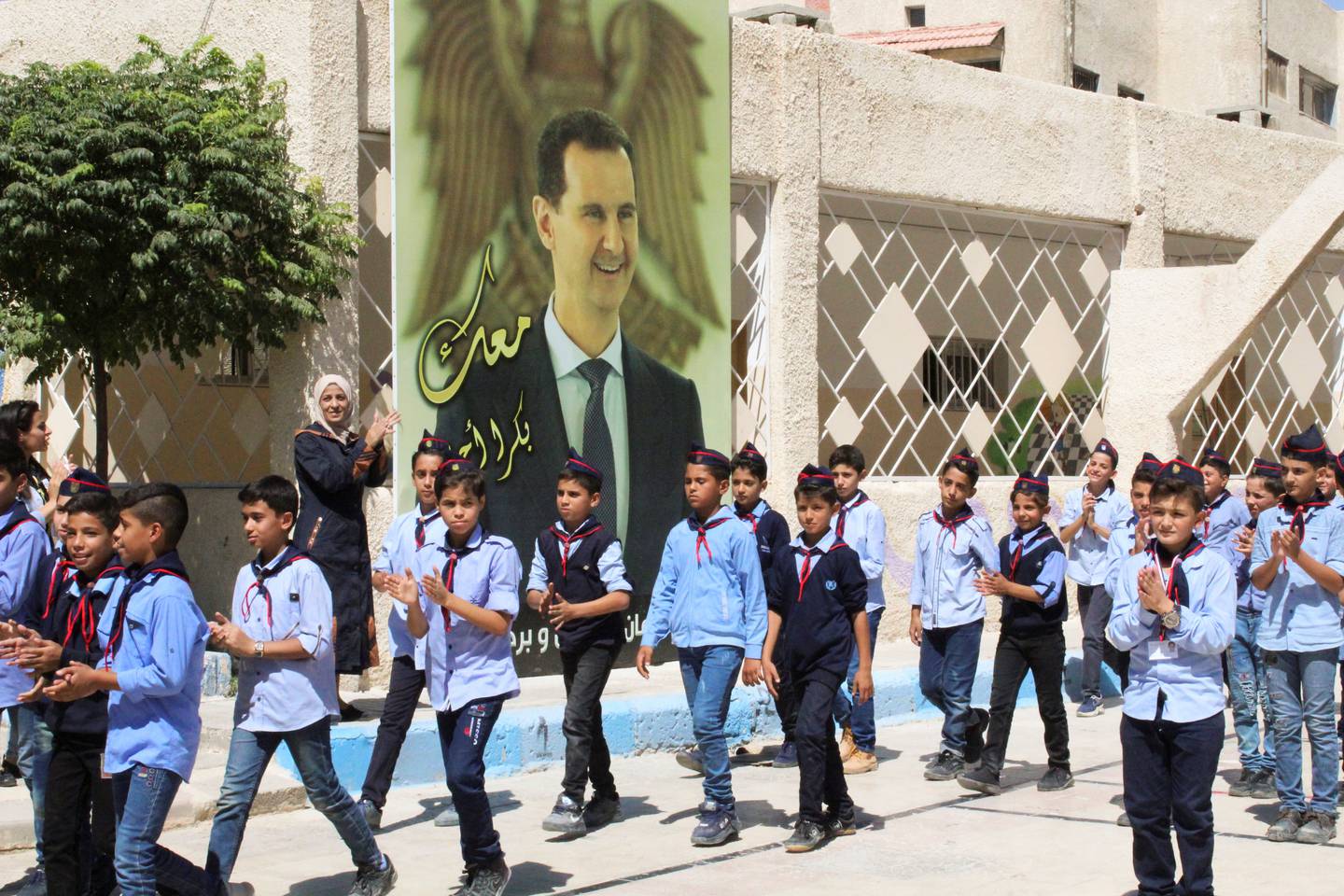 Etter ti år med krig har president Bashar al-Assad igjen fått kontrollen over store deler av Syria. Her går skoleelever i byen Mleiha sør i Syria forbi en stor plakat av Bashar al-Assad.