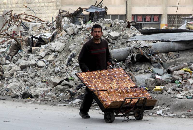 Innbyggerne i Aleppo forsøker å holde seg i live, denne mannen selger boller i den utbombede byen onsdag i forrige uke. FOTO: ABDALRHMAN ISMAIL/NTB SCANPIX