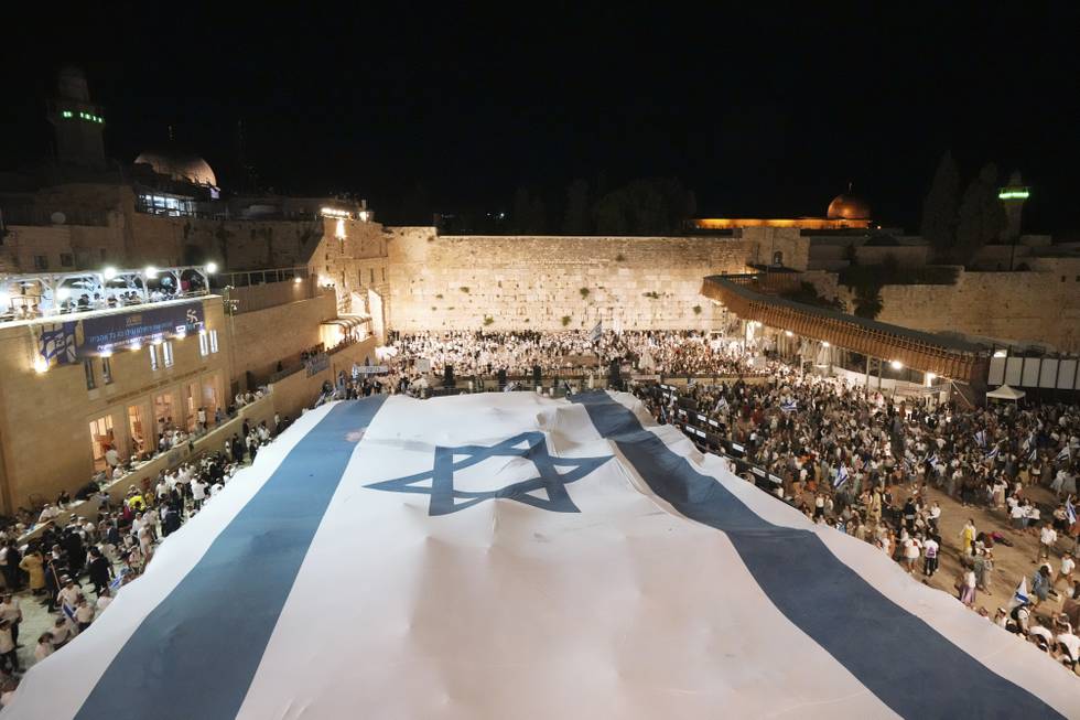 Et gigantisk israelsk flagg ble lørdag kveld rullet ut foran Vestmuren, også kjent som Klagemuren i Jerusalems gamleby, for å feire Israels okkupasjon i 1967. Foto: AP / NTB