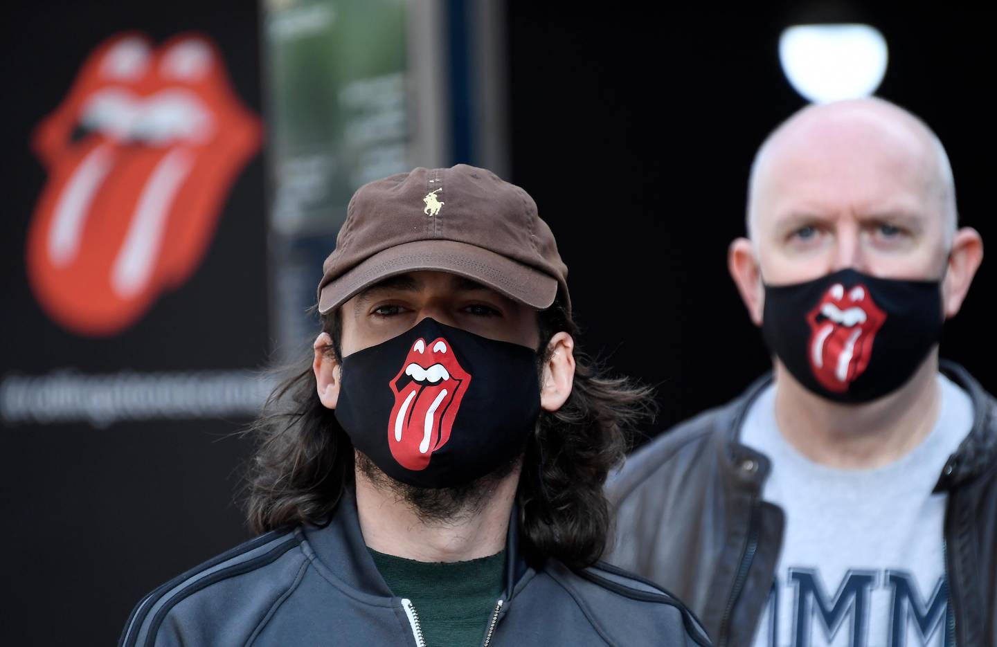 Rolling Stones fans wear face masks as they queue during the opening of Rolling Stones flagship store in London, Wednesday, Sept. 9, 2020. The shop will sell fashion and merchandise, as well as music, from the famous rock band. (AP Photo/Alberto Pezzali)