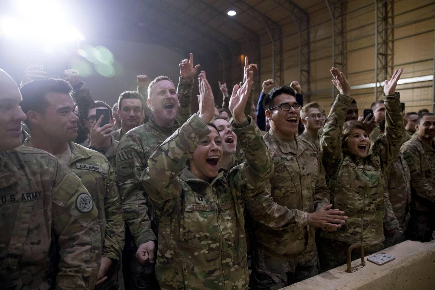 Members of the military cheer as President Donald Trump speaks at a hangar rally at Al Asad Air Base, Iraq, Wednesday, Dec. 26, 2018. President Donald Trump, who is visiting Iraq, says he has 'no plans at all' to remove US troops from the country.  (AP Photo/Andrew Harnik)