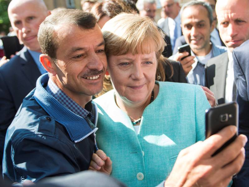 En asylsøker tar en selfie med Merkel i Berlin i september 2015, da flyktningkrisen sto på som verst. 