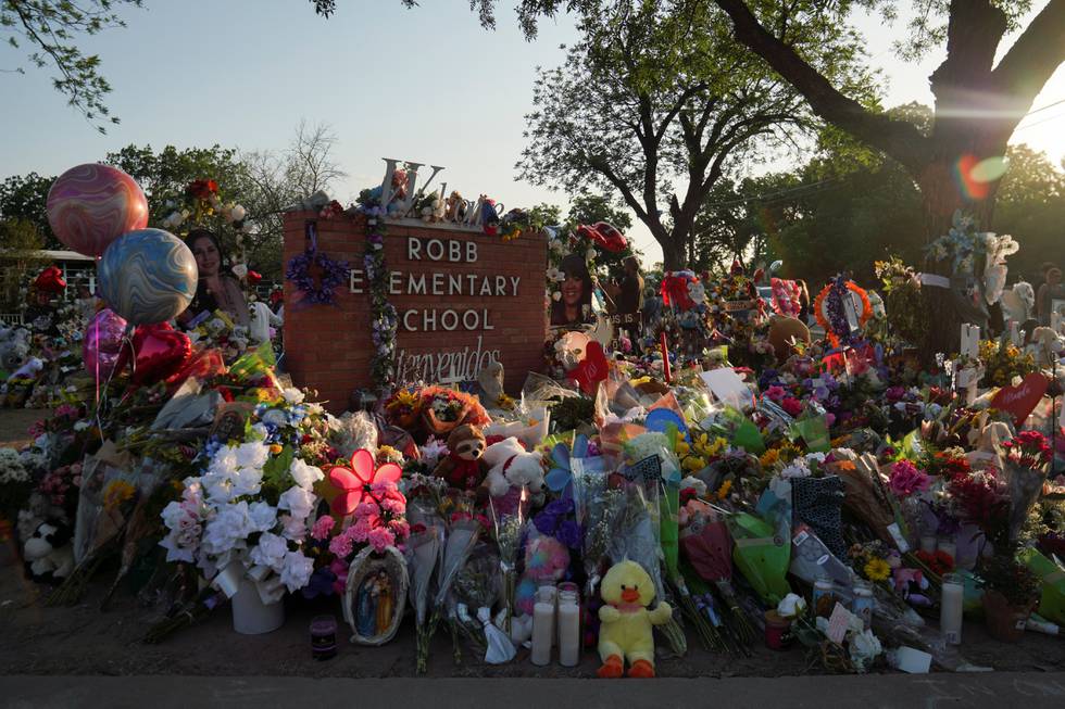 Blomster, leker og andre ting er lagt ned foran Robb Elementary School i Uvalde, Texas. 19 barn og 2 lærere ble drept i en masseskyting ved skolen i mai.
