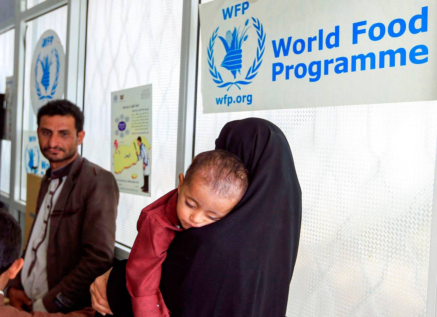 (FILES) In this file photo taken on June 22, 2019 a woman carries a child suffering from malnutrition into a treatment centre of the  World Food Programme (WFP) in al-Sabeen Maternal Hospital in the Huthi-rebel-held Yemeni capital Sanaa. - The World Food Progamme (WFP) wins the 2020 Nobel Peace Prize, the Norwegian Nobel Committee has has announced on October 09, 2020. (Photo by Mohammed HUWAIS / AFP)