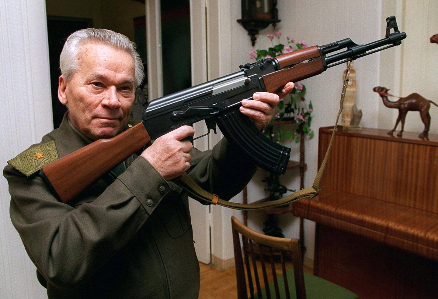 FILE - In this Wednesday, Oct. 29, 1997 file photo Mikhail Kalashnikov shows a model of his world-famous AK-47 assault rifle at home in the Ural Mountain city of Izhevsk, 1000 km (625 miles) east of Moscow. The designer of the world?s most prolific firearm, the AK-47 assault rifle, has written a sorrowful letter to the Russian Orthodox Church?s head, asking if he?s to blame for the deaths of those killed by his creation. According to a Monday, Jan. 13, 2014 report in the daily Izvestia, several months before his death last month at age 94, Kalashnikov wrote to Patriarch Kirill that he keeps asking himself if he?s responsible for those deaths. (AP Photo/Vladimir Vyatkin, File)