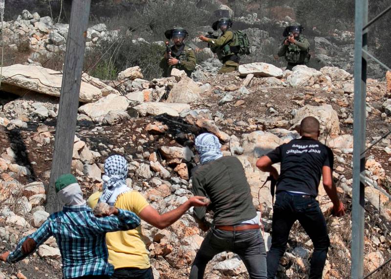 Palestinske demonstranter kaster stein mot israelske soldater. Selv om de står på hver sin side i en konflikt, viser det seg at de har mye til felles genetisk. Illustrasjonsfoto.