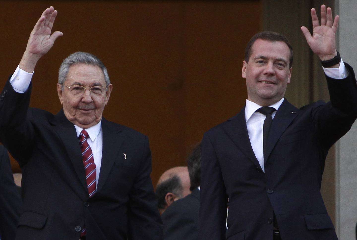 Cuba's President Raul Castro, right, and Russia's Prime Minister Dmitry Medvedev, left, wave to journalists after a wreath-laying ceremony at the Jose Marti monument in Havana, Cuba, Thursday, Feb. 21, 2013. (AP