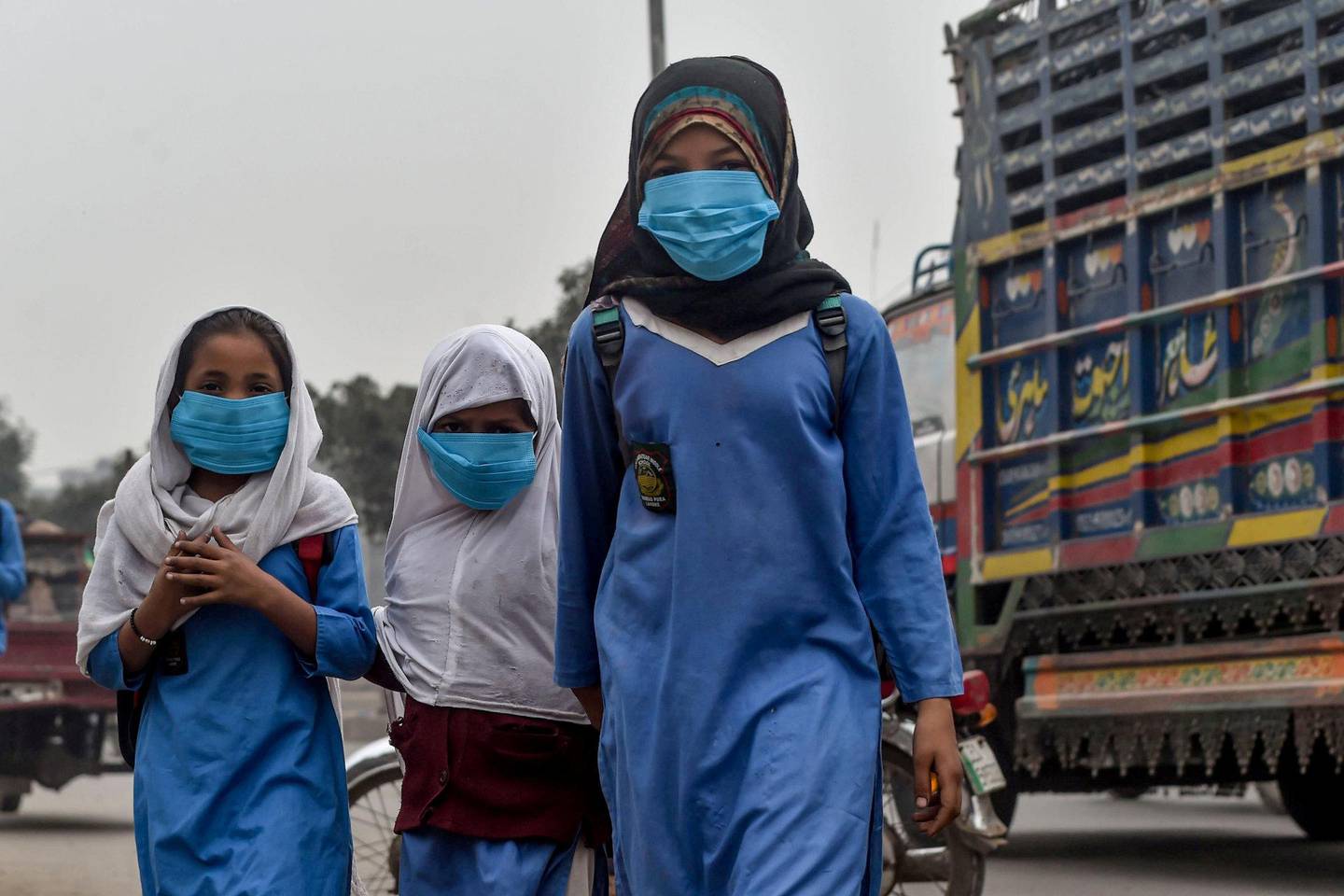 Barn i Pakistan beskytter seg fra luftforurensing. Luftforurensing er en sentral del av Norges nye strategi. Foto: NTB scanpix