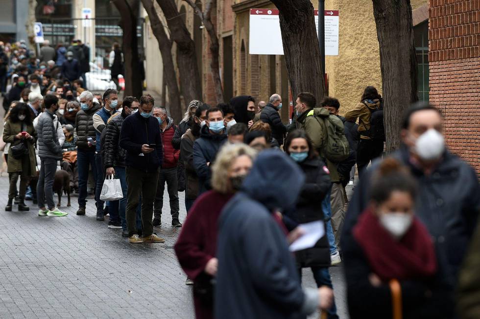 Voters queue outside a polling station in Barcelona during regional elections in Catalonia on February 14, 2021. - Catalonia is voting in an election overshadowed by the pandemic which Madrid hopes will unseat the region's ruling separatists more than three years after a failed bid to break away from Spain. (Photo by Josep LAGO / AFP)