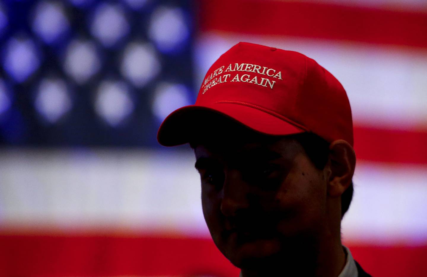 Oliver Lester, of Montgomery, wears a hat with President President Donald Trump's campaign slogan as he watches results come in for Gov. Kay Ivey at a watch party, Tuesday, Nov. 6, 2018, in Montgomery, Ala. (AP Photo/Butch Dill)