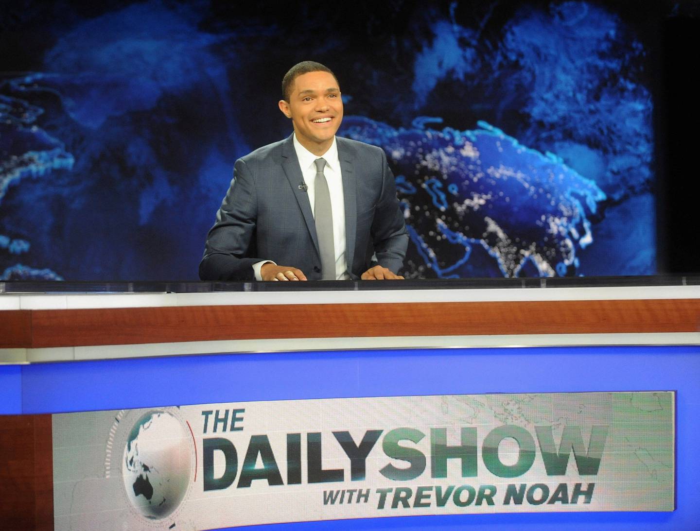 Det er slik vi er vant med å se Trevor Noah, bak skrivebordet i «The Daily Show». FOTO: NTB SCANPIX