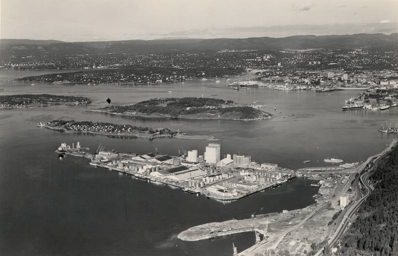 Flyfoto av Sjursøya i 1965. Øya hadde nå gassverk, bensinhavn og verksted for Havnevesenet