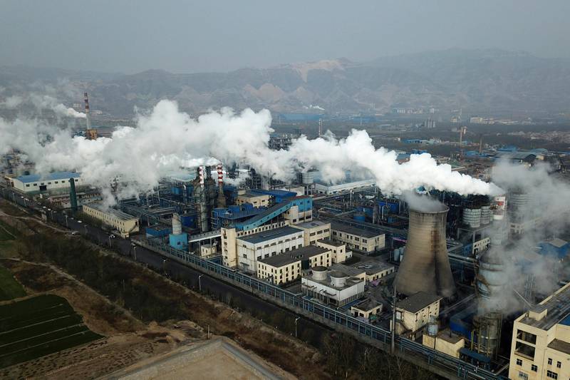 In this Nov. 28, 2019, photo, smoke and steam rise from a coal processing plant that produces carbon black, an ingredient in steel manufacturing, in Hejin in central China's Shanxi Province. As world leaders gather in Madrid to discuss how to slow the warming of the planet, a spotlight is falling on China, the top emitter of greenhouse gases. China burns about half the coal used globally each year. Yet it's also the leading market for solar panels, wind turbines and electric vehicles. (AP Photo/Sam McNeil)