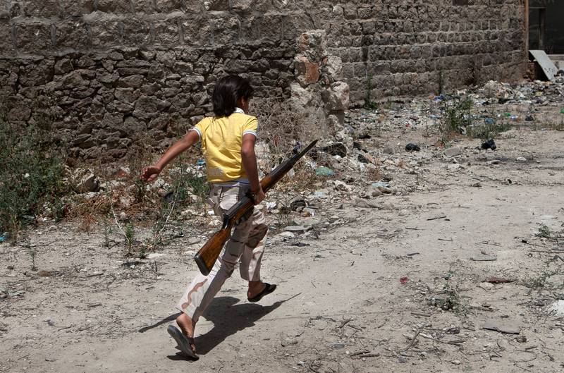 Flere syriske barn blir rekruttert til krigsdeltakelse, ifølge UNICEF. All bruk av barn i krig som å bære våpen eller lage mat til soldatene, er ulovlig etter internasjonal rett. Denne syriske gutten bærer et gevær for opprørere som slåss i byen Maaret al-Numan i Idlib sør i Syria. FOTO: DANIEL LEAL-OLIVAS / NTB SCANPIX