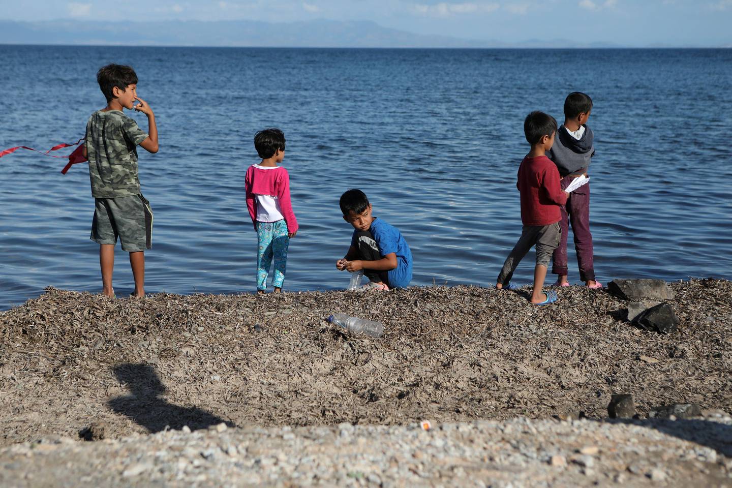 FILE PHOTO: Children stand next to the sea at the Kara Tepe camp for refugees and migrants on the island of Lesbos, Greece, October 14, 2020. REUTERS/Elias Marcou/File Photo