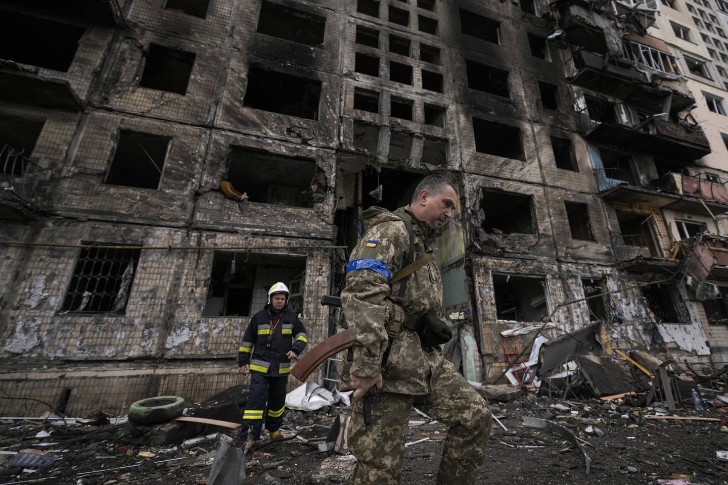 Ukrainske soldater og brannfolk leiter gjennom et bombet høyhus i Kyiv mandag 14. mars.