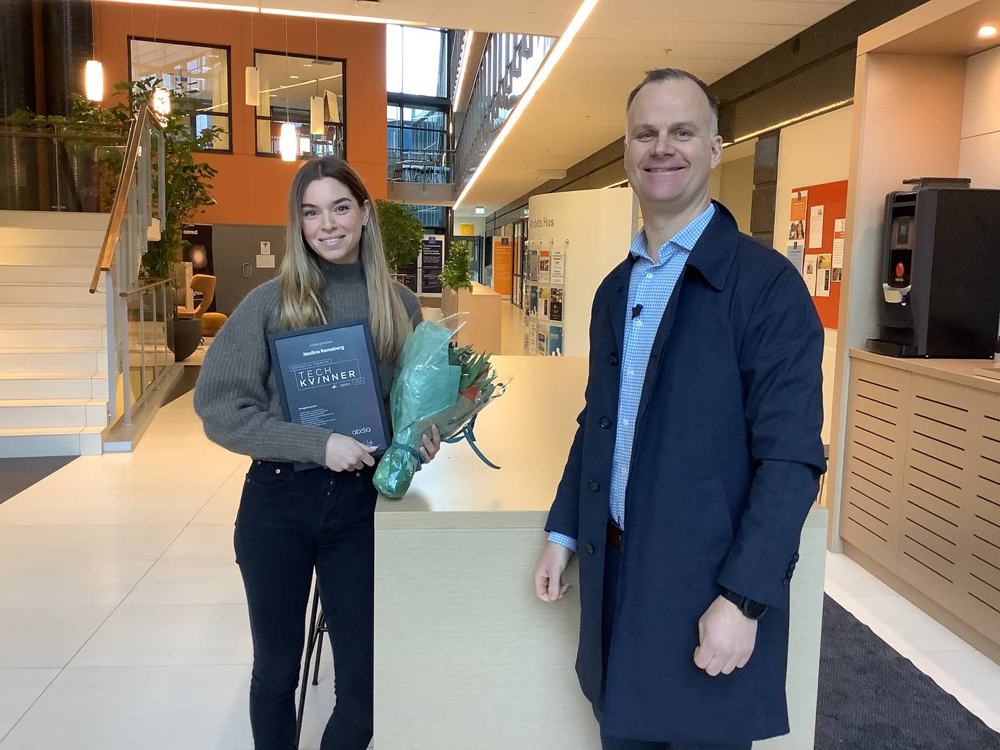 En fornøyd regiondirektør for Webstep i Stavanger, Geir Jåthun Hindenes, overrekker Nadine Ramsberg både diplom og blomster, som tegn på at hun er blant Norges fremste tech-kvinner.