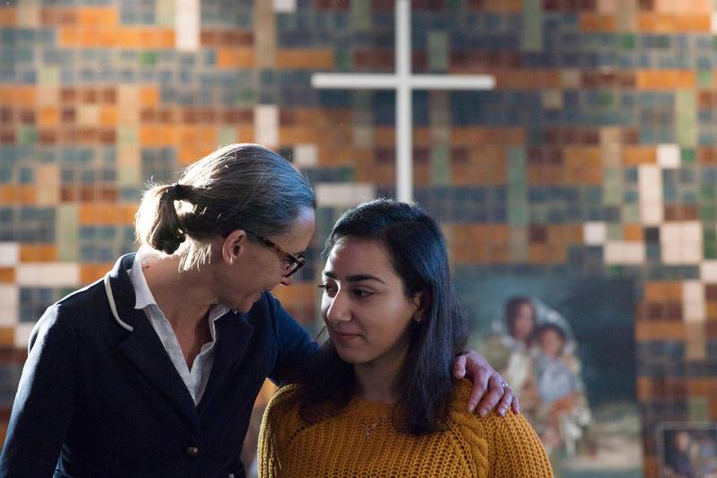 In this Thursday Dec. 13, 2018, file image, Hayarpi Tamrazyan, a 21-year-old Armenian asylum seeker, right, gets a hug from spokesperson Florine Kuethe inside the Bethel chapel in The Hague, Netherlands. A non-stop service started in October by a Dutch protestant church to protect a family of Armenian asylum seekers from deportation is ending after the government announced changes to its immigration policy. (AP Photo/Peter Dejong)