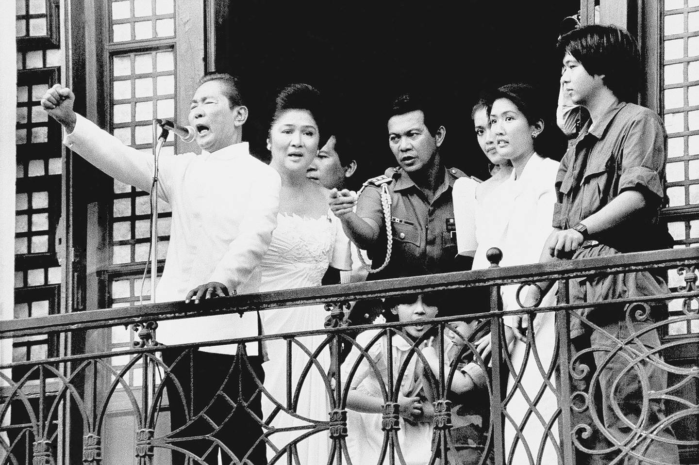 Ferdinand Marcos holdt sin siste tale til folket fra balkongen i presidentpalasset før han rømte landet i februar 1986. Kona hans Imelda står bak ham, lengst til høyre står Ferdinand Marcos junior som nå blir Filippinenes nye president.