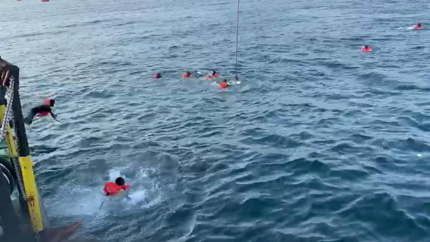 A migrant jumps overboard from Spanish rescue ship Open Arms and others swim away after more than 40 of them jumped from the ship to attempt to reach the coast, at sea near Palermo, Italy, in this still image taken from video, September 18, 2020. Open Arms/Handout via REUTERS ATTENTION EDITORS - THIS PICTURE WAS PROVIDED BY A THIRD PARTY. BEST QUALITY AVAILABLE