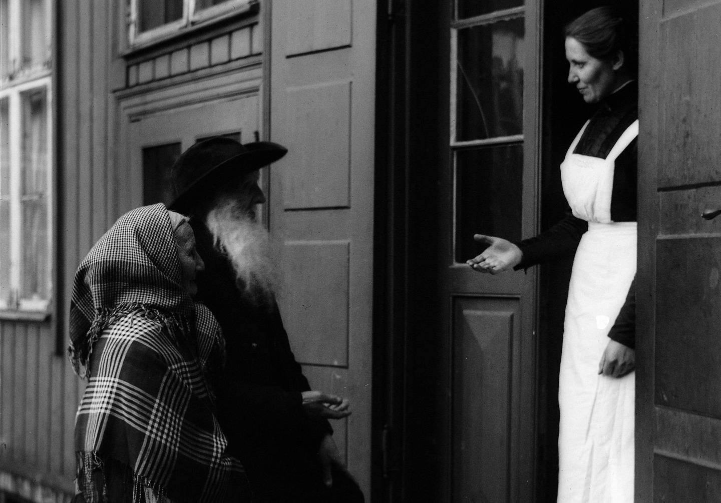 Slumsøster Kornelie Bernardine Danielsen tar imot to nye beboere på Frelsesarmeens gamlehjem Kveldssol i Verksgata 14 på Rodeløkka ca. 1920–1930.