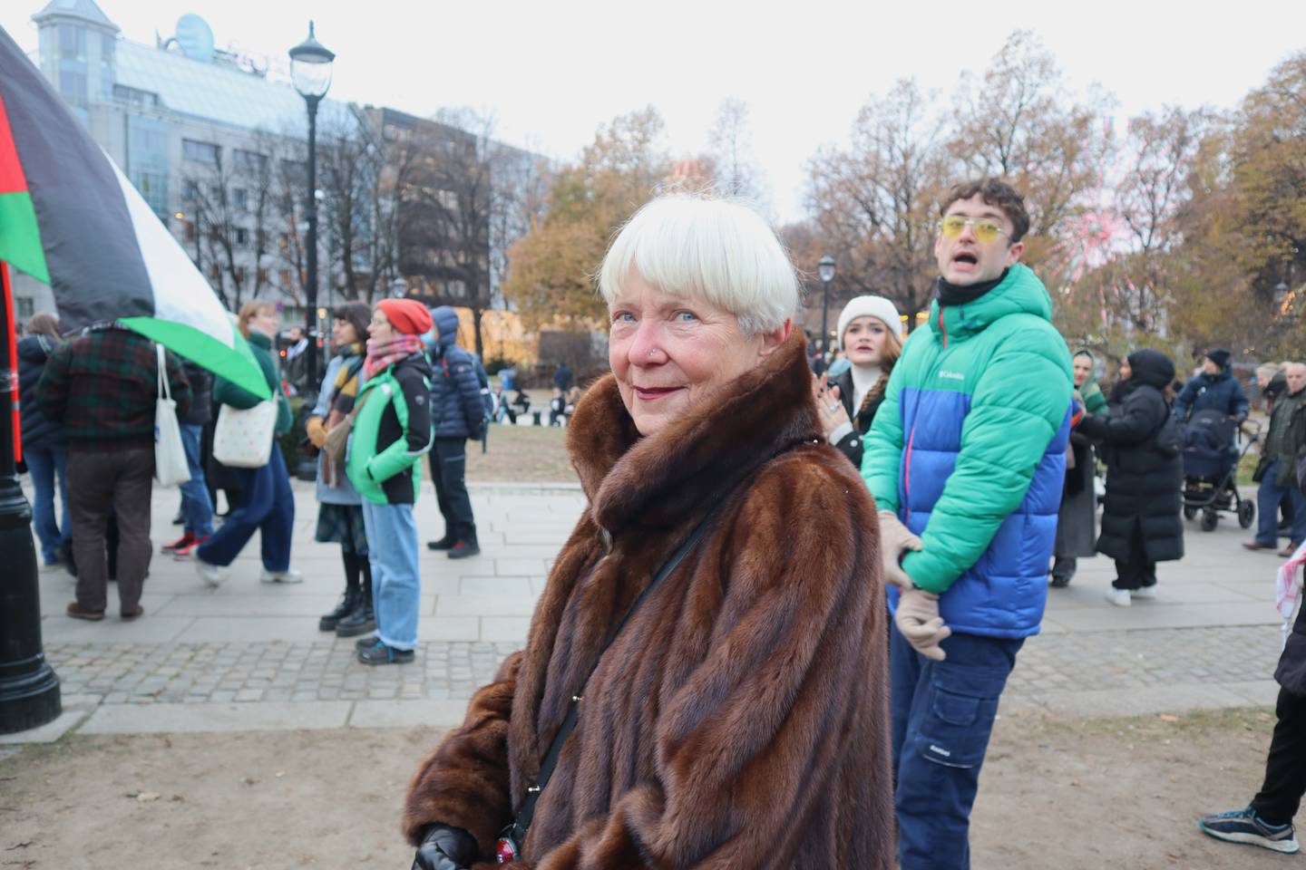 Eldre dame i pelskåpe på demonstration.
