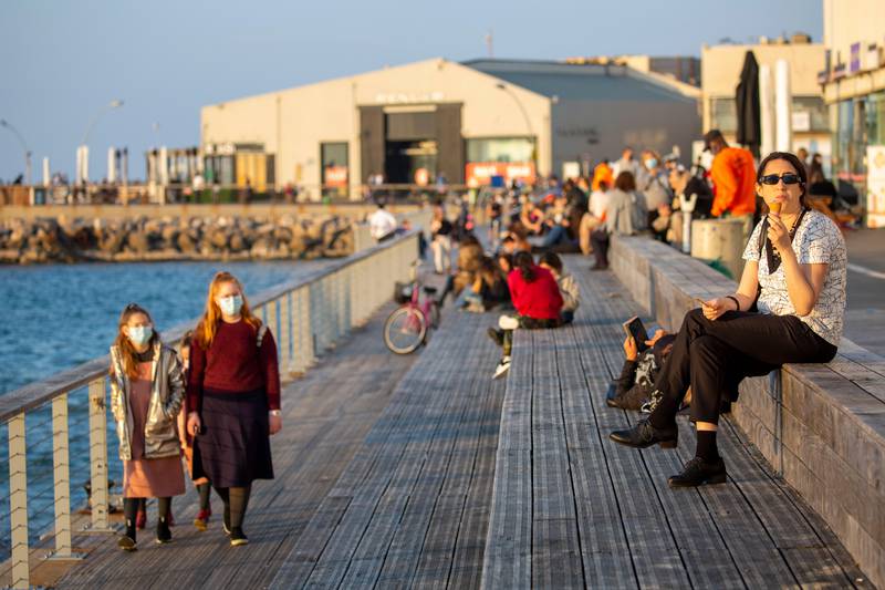 People enjoy the promenade on the Mediterranean sea in Tel Aviv, Israel, Sunday, Feb. 7, 2021. Israel has started to ease restrictions nearly six weeks after entering its third nationwide lockdown to prevent the spread of the coronavirus. (AP Photo/Ariel Schalit)