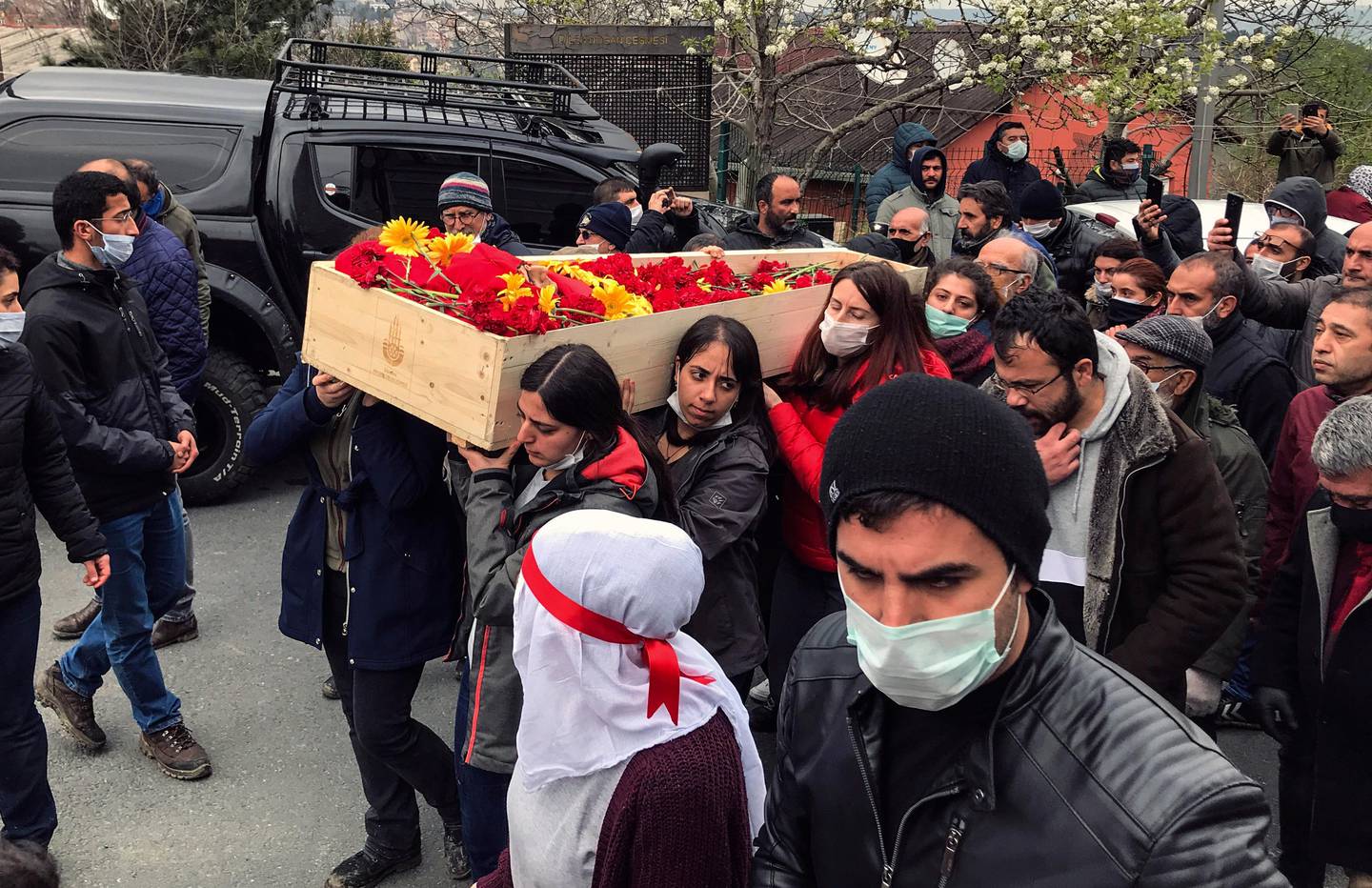 Mourners carry the open coffin of Helin Bolek, a member of a popular folk music group that is banned in Turkey, during the funeral procession in Istanbul, Friday, April 3, 2020. Bolek died at home Friday on the 288th day of a hunger strike protesting the government's treatment of the band, in an effort to force the government to reverse its treatment of the band and its members. She was 28. Grup Yorum, known for its protest songs, is a folk collective with rotating band members, the government accuses the group of links to the outlawed Revolutionary People's Liberation Party-Front, or DHKP/C. (Ibrahim Mase/DHA via AP)