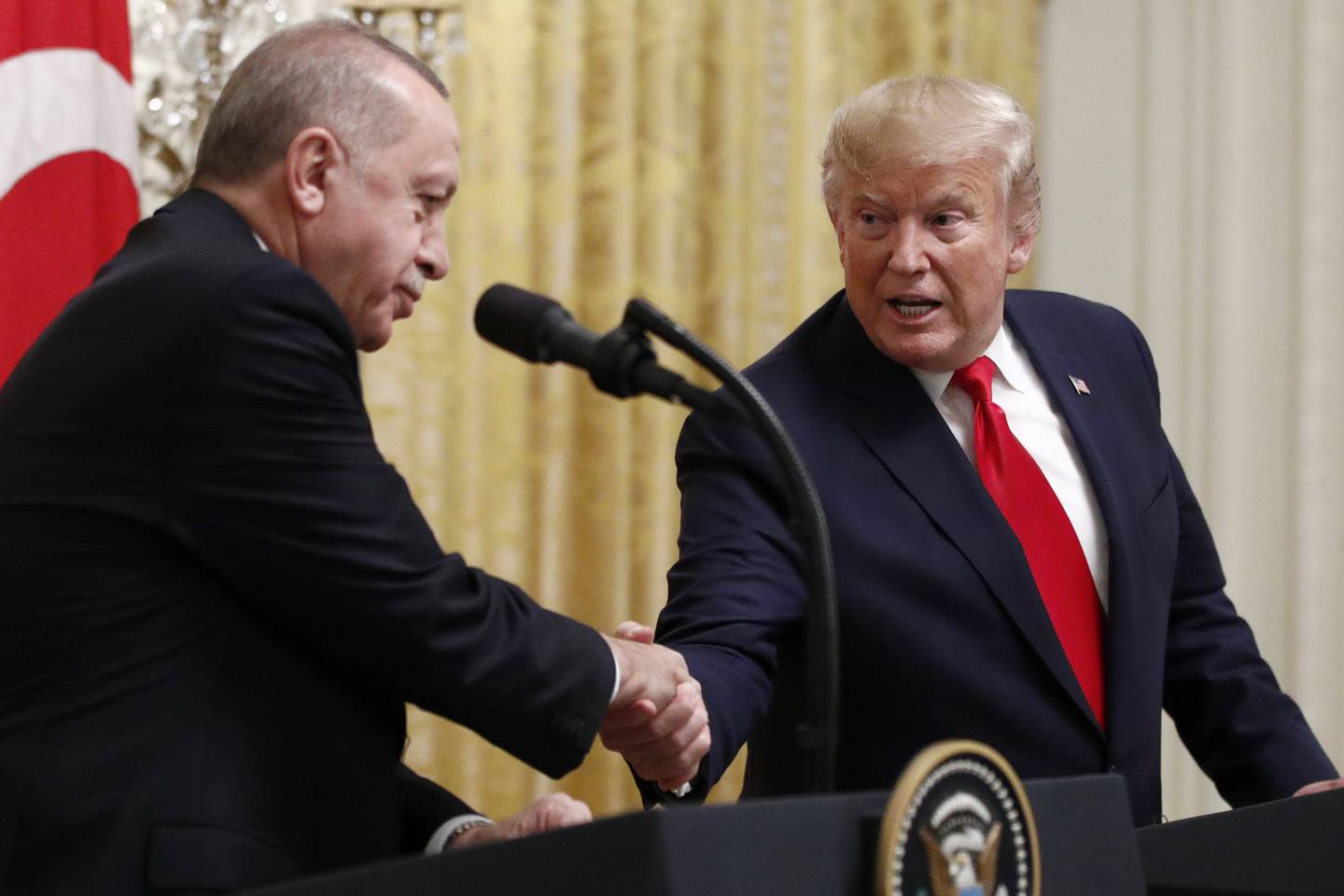 FILE - In this Nov. 13, 2019 file photo, President Donald Trump shakes hands with Turkish President Recep Tayyip Erdogan during a news conference in the East Room of the White House in Washington.  The State Department says recent congressional action to recognize the Armenian genocide does not reflect Trump administration policy. That statement is likely to pleaseErdogan. The Senate voted unanimously last week to recognize the mass killings of more than a million Armenians by Ottoman Turks a century ago as a genocide.  (AP Photo/Patrick Semansky)
