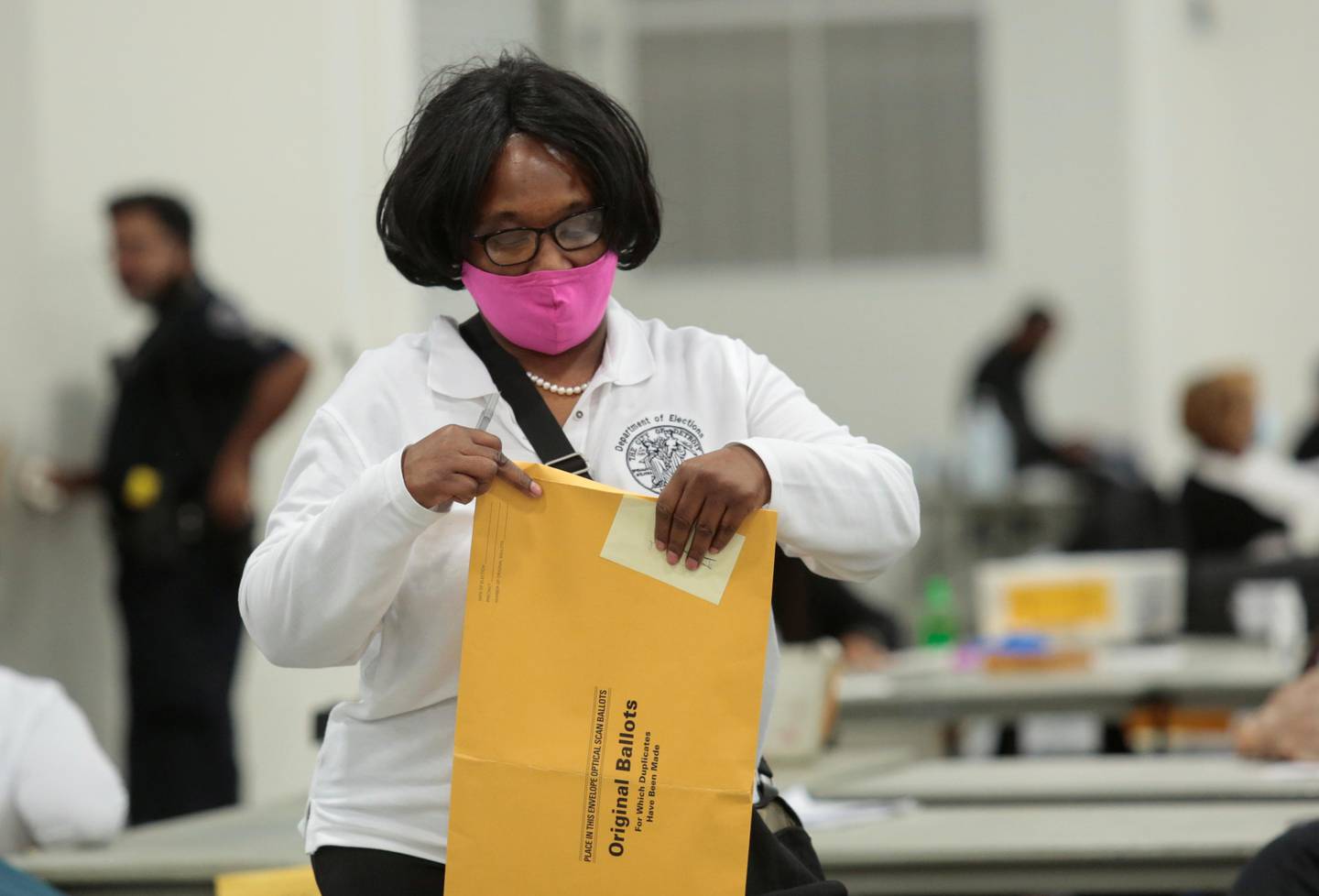 A poll worker supervisor handles an envelope of original ballots at the TCF center after Election Day in Detroit, Michigan, U.S., November 4, 2020. REUTERS/Rebecca Cook
