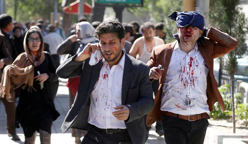 Skadede sivile løper vekk fra åstedet der en kraftig bombe gikk av i ambassadestrøket i Kabul den 31. mai. Dødstallet har oversteget 150. Det er foreløpig ikke avklart hvem som sto bak.