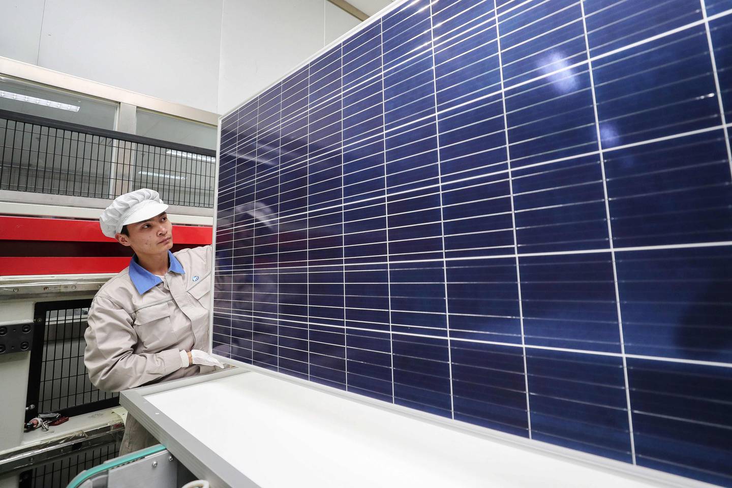 This photo taken on February 27, 2019 shows a worker checking newly-made solar panels at a factory in Lianyungang in China's eastern Jiangsu province. - China's manufacturing activity shrunk for a third straight month in February, sinking to its worst performance in three years as the economy slows and the US trade war bites, official data showed on February 28. (Photo by STR / AFP) / China OUT