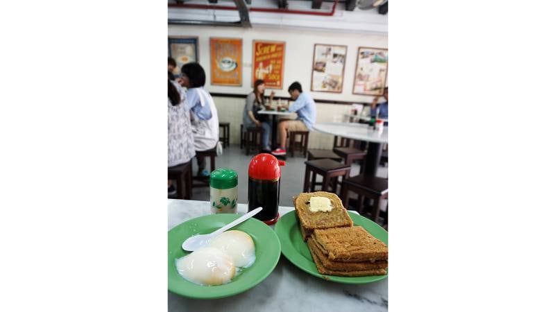 Typisk frokost i Singapore: Kayatoast med egg, soyasaus og kokossyltetøy og kopi – søt, tykk kaffe! 