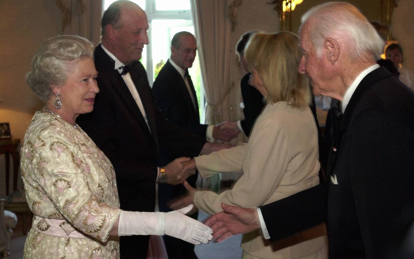 Dronning Elizabeth, her fra statsbesøket i Norge i 2001. Her hilser hun på eventyreren Thor Heyerdahl. I bakgrunnen kong Harald og prins Philip. Foto: Knut Fjeldstad / NTB
