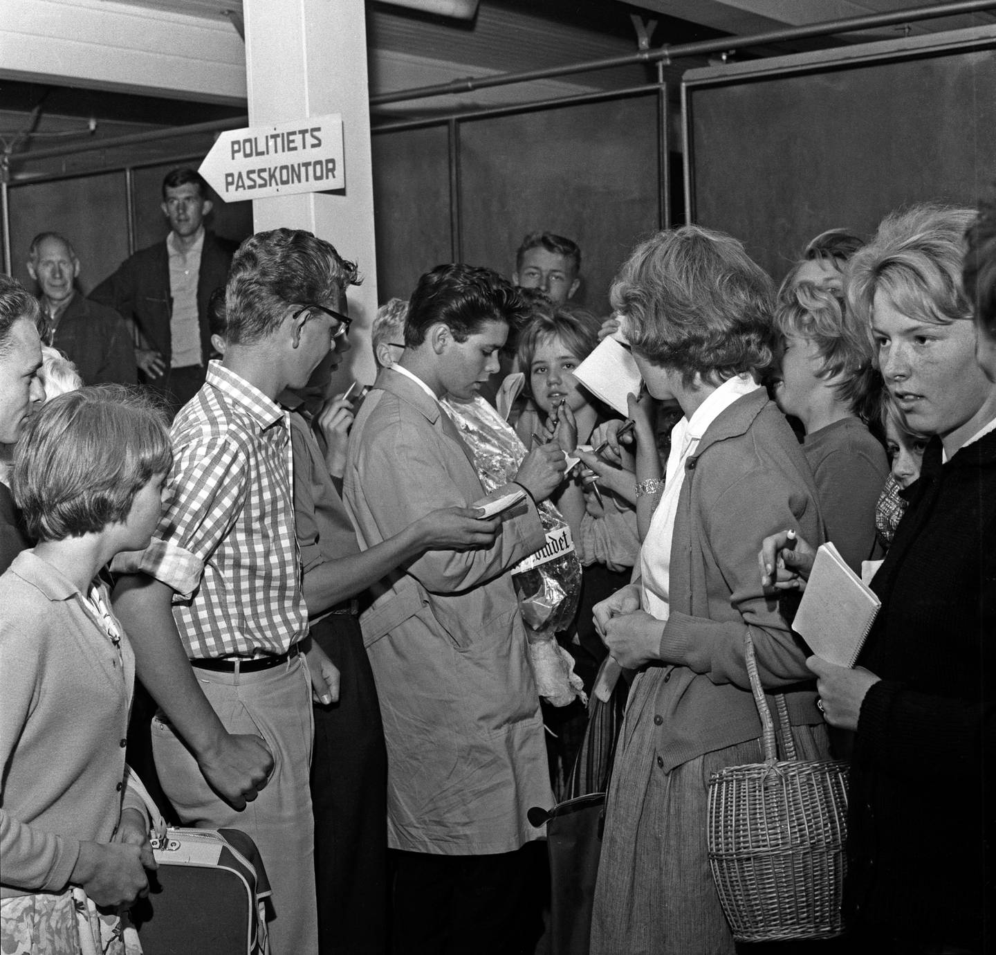 Cliff Richard omringet av fans som ville ha autografen hans, på Fornebu 21. august 1961