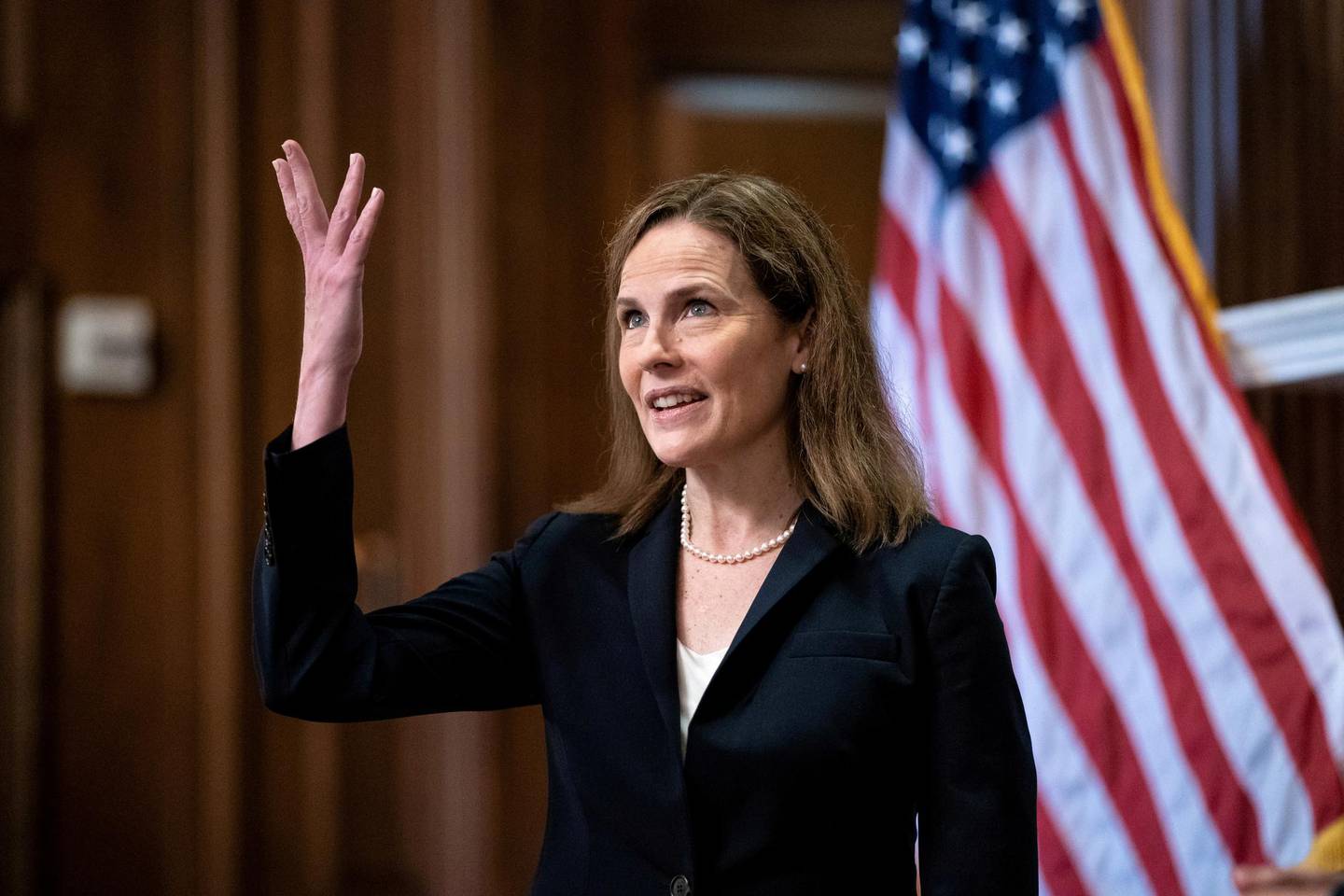 FILE PHOTO: Judge Amy Coney Barrett, U.S. President Donald Trump's Nominee for Supreme Court, gestures during a photo before a meeting with Senator Roy Blunt (R-Mo) on Capitol Hill in Washington DC, U.S. October 21, 2020. Anna Moneymaker/Pool via REUTERS/File Photo