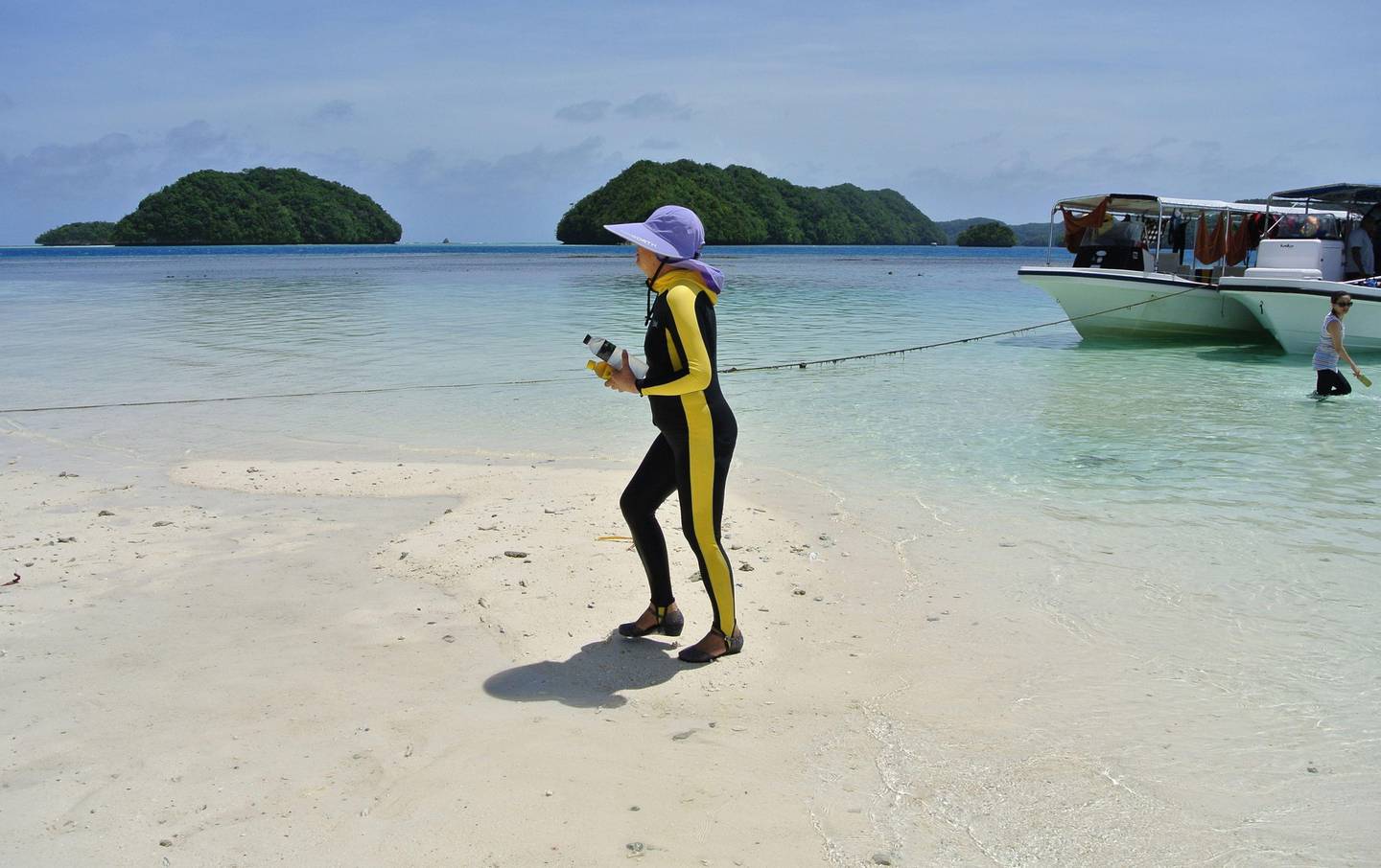 (FILES) This file picture taken on March 6, 2015 shows a Chinese tourist walking on a beach on the Rock Islands in Palau.
Visitors to the tiny Pacific nation of Palau are being made to sign a promise to respect the environment, in an innovative move that authorities hope will curb ecological damage caused by booming numbers of tourists. / AFP PHOTO / SEBASTIEN BLANC