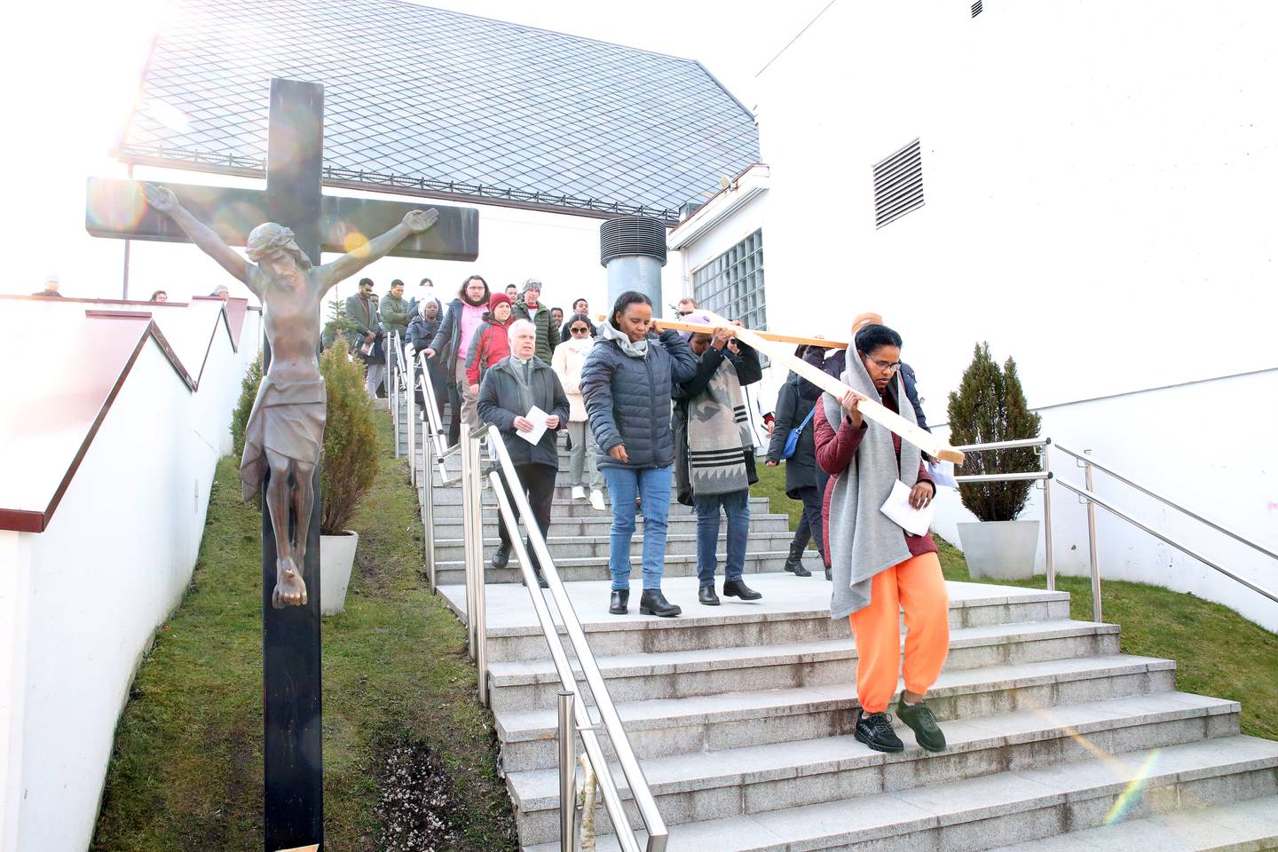 En gruppe katolikker bærer korset ned trappen fra St. Svithun kirke. Jesus-figuren til venstre har fast tilhold der.