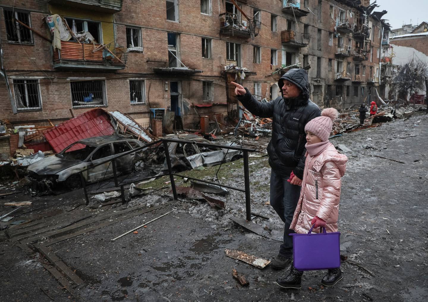 Innbyggere går forbi ødelagte bygninger etter russiske angrep i byen Vysjhorod nær Kyiv.