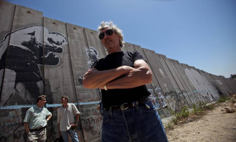 Roger Waters ved muren Israel har oppført på vestbredden. Han har lovet å holde en konsert på området hvis muren blir revet. FOTO: MUHAMMED MUHEISEN/NTB SCANPIX