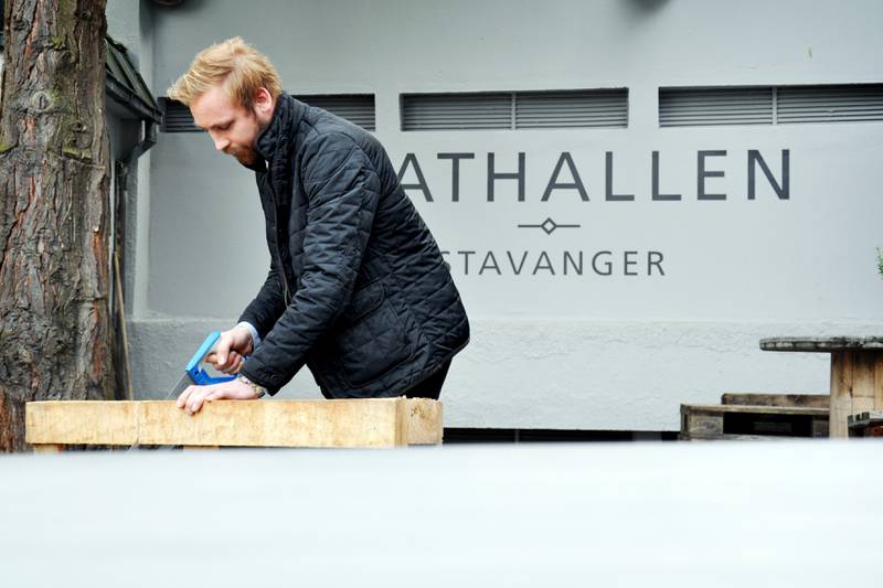 Jacob Helle i Mathallen sager i en palle som skal brukes i forbindelse med alkoholservering. Foto: Tone Helene Oskarsen