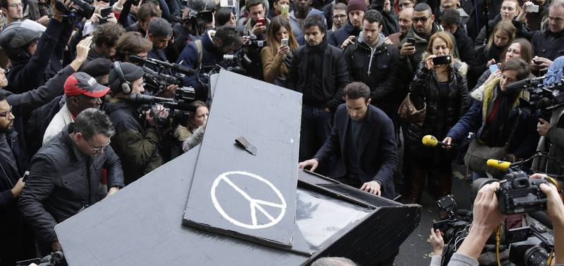 Den tyske pianisten Davide Martello tok med pianoet sitt til Bataclan og spilte «Imagine» for folk lørdag. Det samme gjorde han utenfor lokalene til Charlie Hebdo tidligere i år. FOTO: NTB SCANPIX